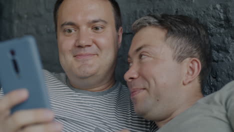 happy gay couple looking at phone