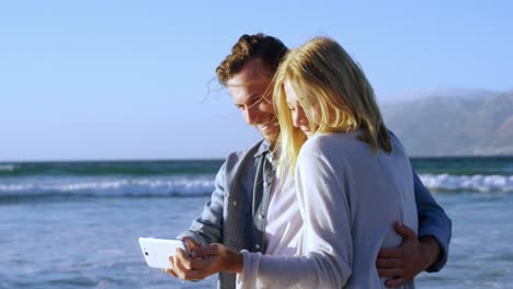 couple taking selfie on mobile phone at beach