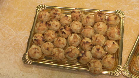 almond and nut-studded cookies on gold trays