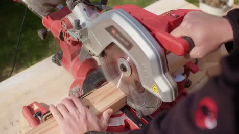 the craftsman carefully cuts the marked piece of wood