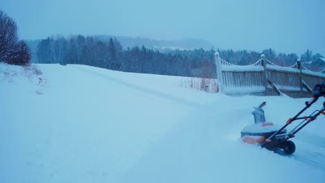 Hombre-Europeo-Empujando-Quitanieves-En-El-Patio-Trasero,-Limpiando-Nieve-Durante-El-Invierno-En-Noruega