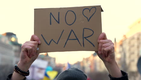 protest sign against war raised overhead in slow motion, prague rally