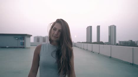 girl walks along empty roof against sunset slow motion