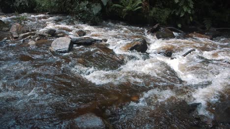 Primer-Plano-De-Agua-Que-Fluye-A-Través-De-Un-Río-Con-Rocas-En-Cámara-Lenta-En-El-Valle-De-Cocora,-Colombia