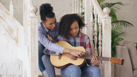 two friends learning guitar