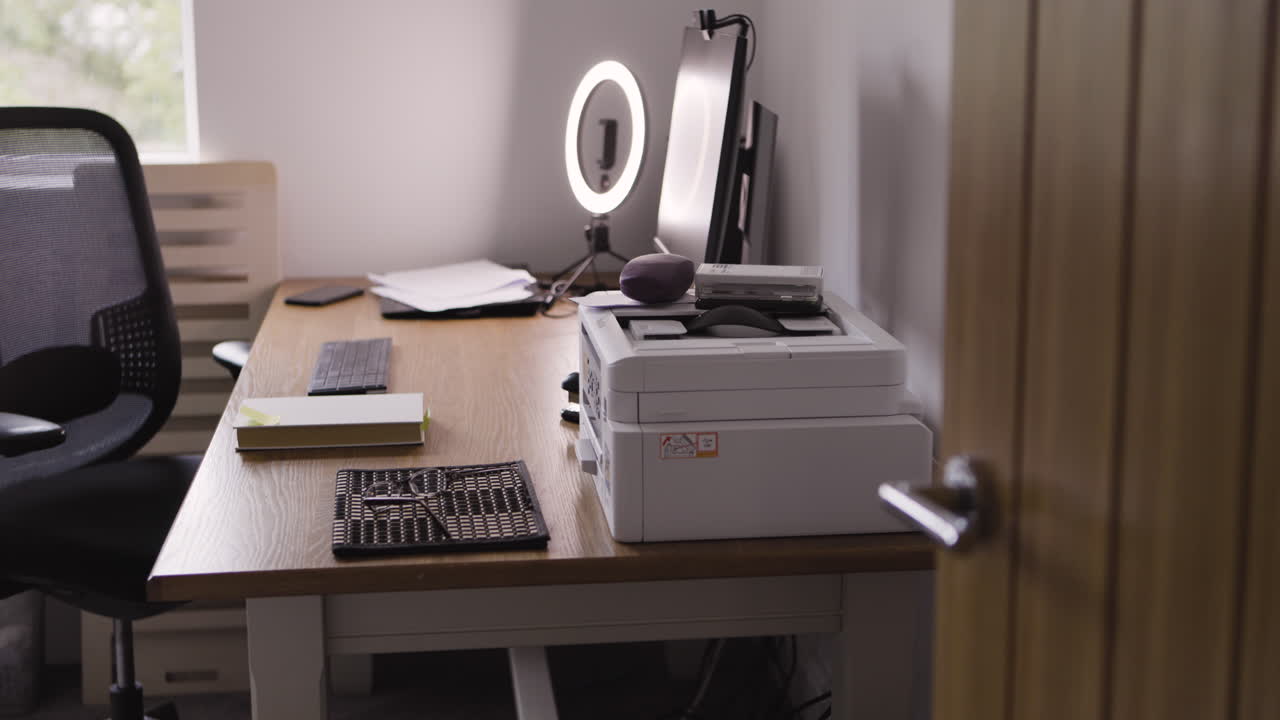 A desk with a computer, printer, and office supplies