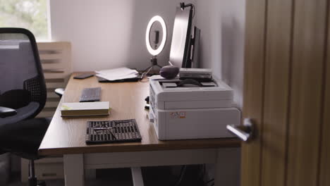a desk with a computer, printer, and office supplies