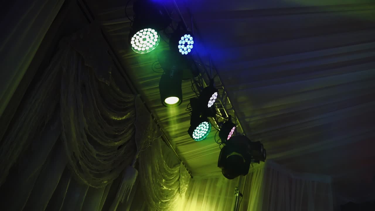 Lights flashing on the ceiling of a nightclub. Colorful spotlights spinning and glittering during the dance party.