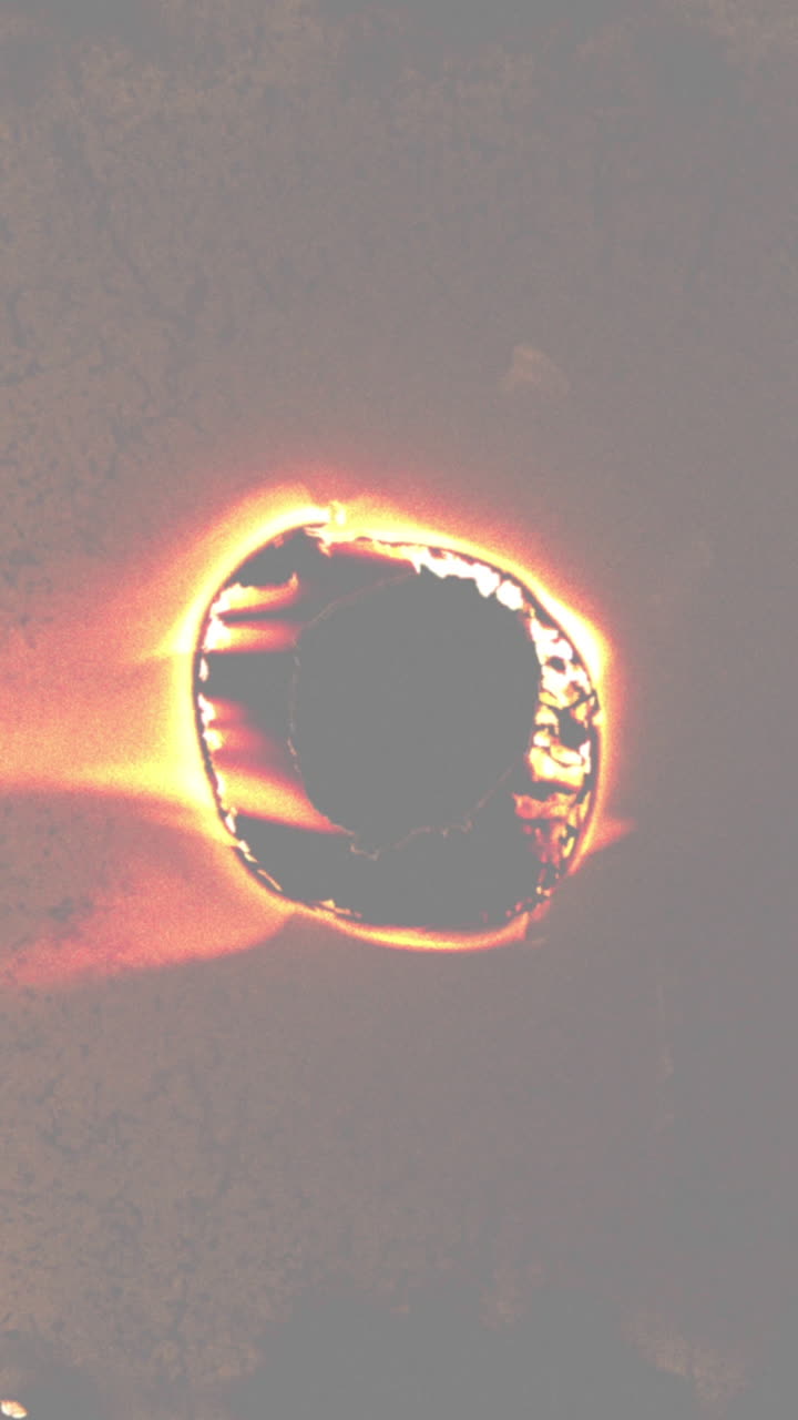 Burning Hole in Paper with Glowing Orange and Yellow Edges