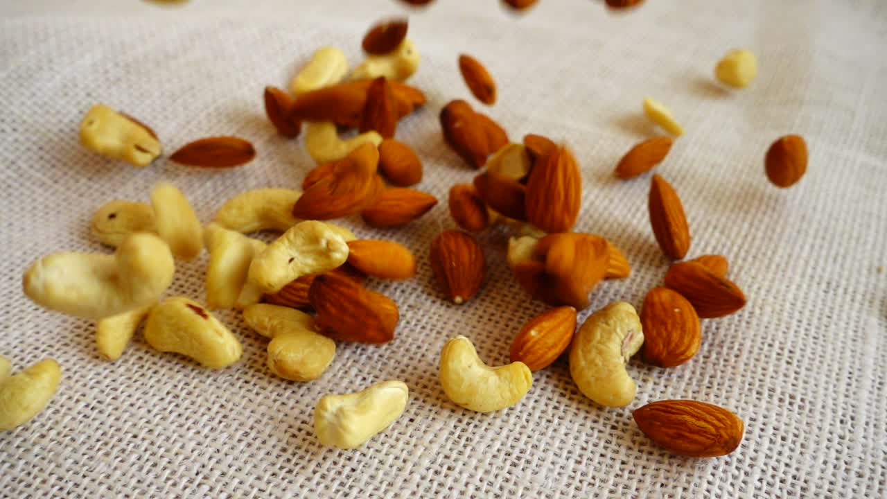 Almonds nuts and cashews nuts. Shooting while falling on a sack. Slow motion