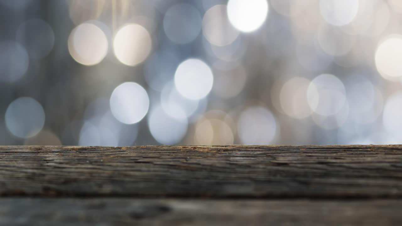 Video di punti luce bokeh tremolanti bianchi con spazio per il testo e superficie in legno