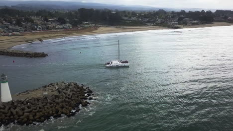 Aerial-view-around-a-catamaran-leaving-Santa-Cruz,-in-cloudy-California,-USA