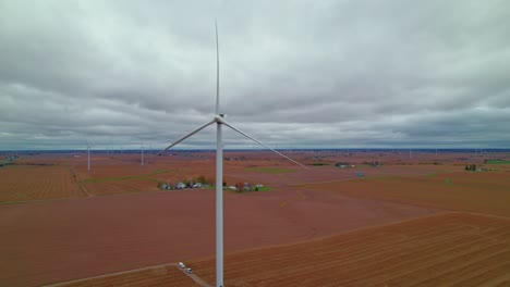 wind turbine dominating the foreground in an expansive iowa farmland under a vast sky