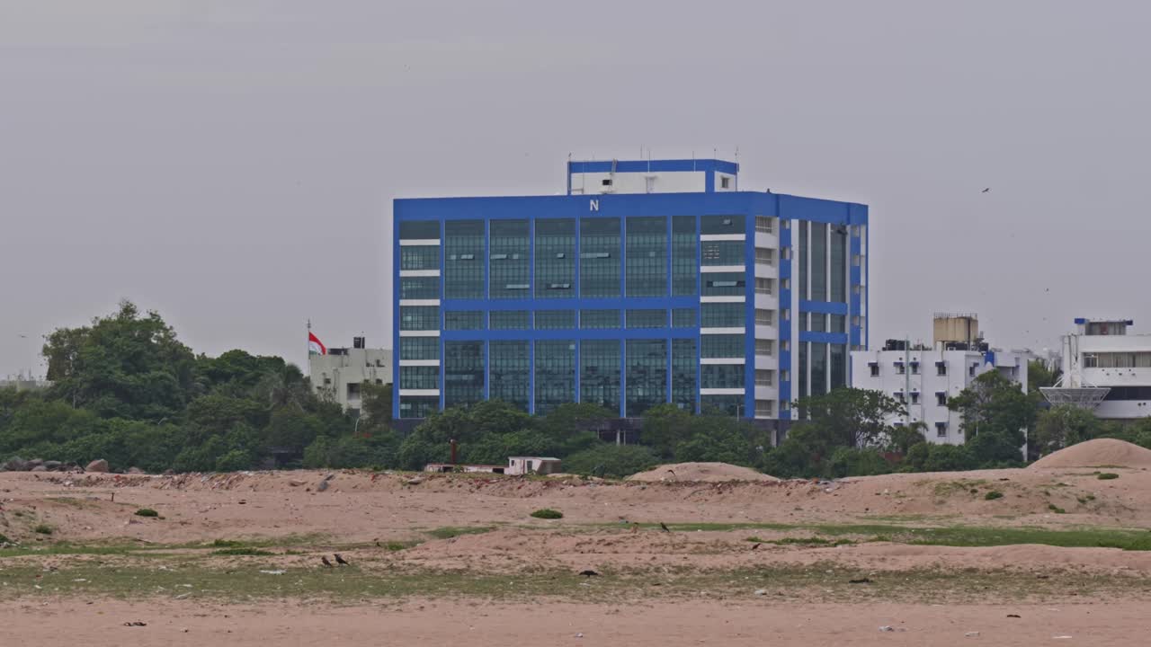 Maritime Rescue Coordination Center (MRCC) Building with sand, trees and crows at Varuna Salai road, Port Trust Officers Quarters, Sathya Nagar, Chennai, Tamil Nadu, india. day time, pan shot, 4k.