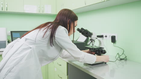 scientist looking through a microscope in a laboratory