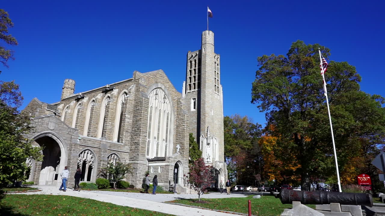 Gothic church and bell tower with flag poles and cannon.