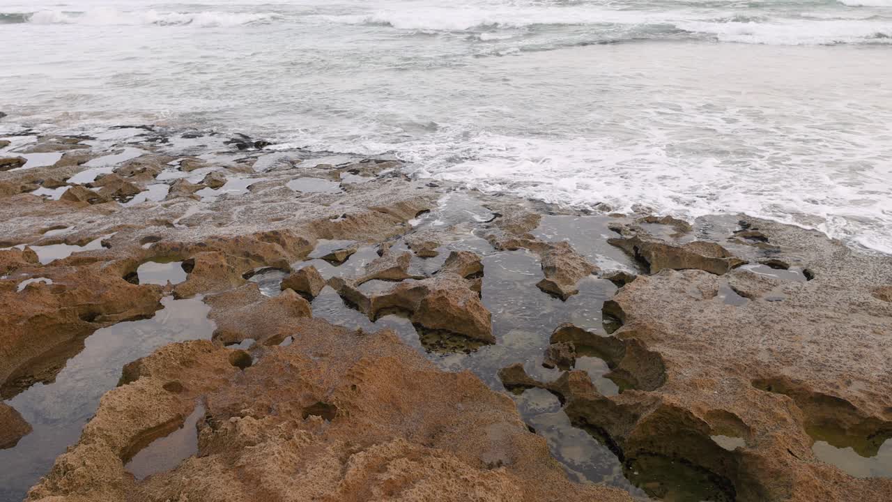 Onde oceaniche che si infrangono nelle pozze di roccia della penisola di Mornington