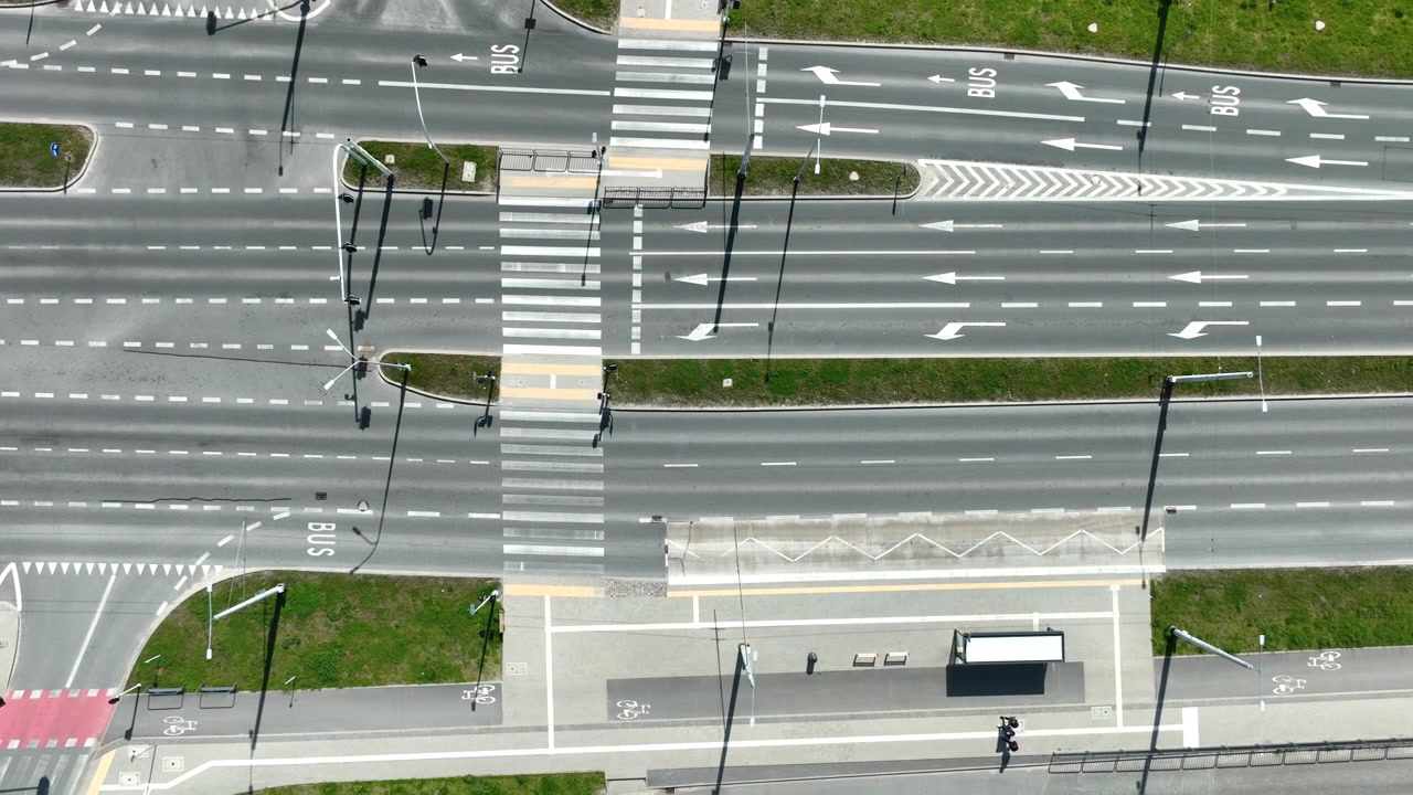 Cinematic top down aerial shot of a modern urban multilane highway with bus lanes and zebra crossings in Gdynia. Ideal for urban planning and smart city concepts.