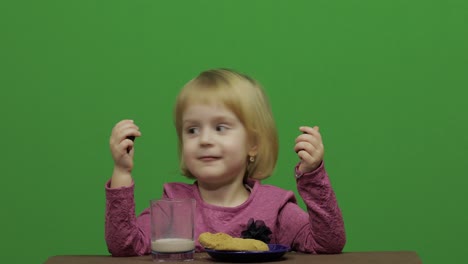 Niña-Sentada-En-La-Mesa-Y-Comiendo-Chocolate,-Galletas-Y-Bebidas-Cacao