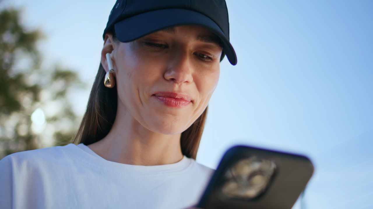 Stylish lady messaging cellphone outdoors closeup. Portrait happy woman texting