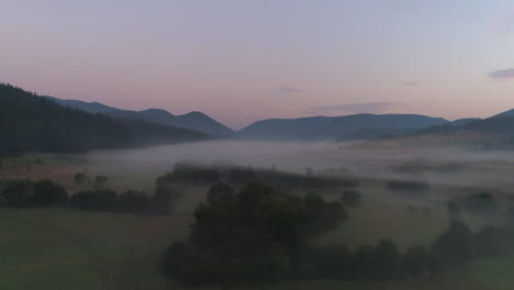mountains enveloped by mist early in the morning