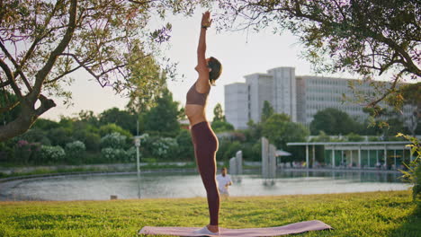 slim lady stretching hands at sunshine place. fit woman training muscles alone