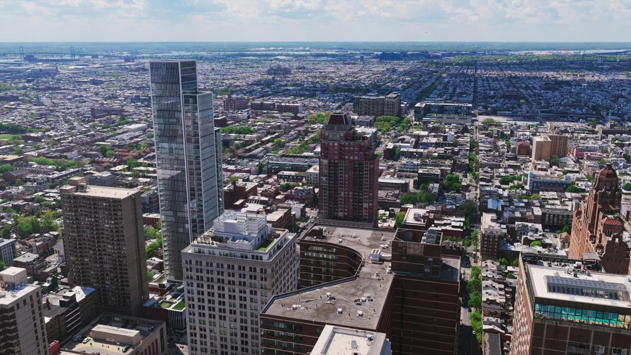 Aerial drone view of Philadelphia's Center City skyline looking south, featuring the Arthaus tower, Divine Lorraine, residential high-rises, and the Delaware River.
