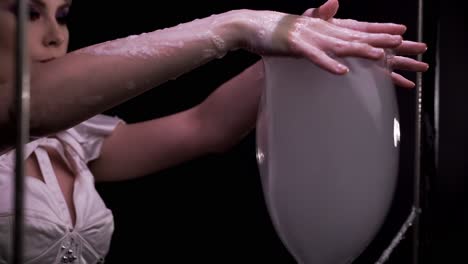 close-up girl takes two big bubbles with her hands then turns them into smoke flowing soapy water