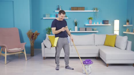 Clumsy-man-looking-at-phone-while-cleaning-and-banging-his-foot-on-bucket.