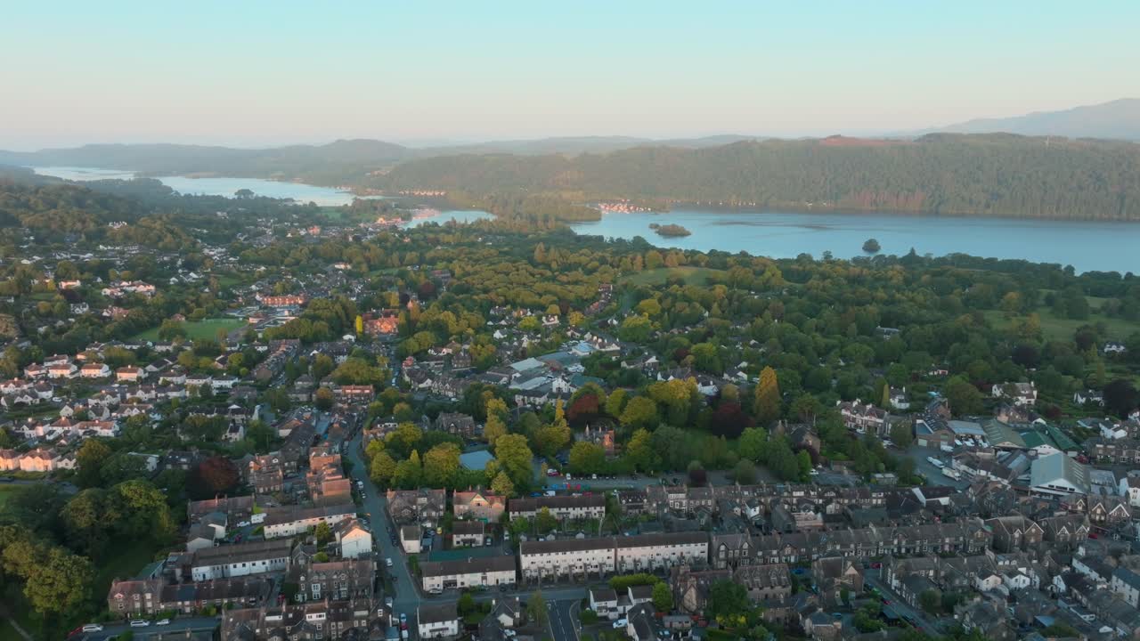 Kota pedesaan tepi danau saat matahari terbit dengan gerakan kamera mundur dan danau di latar belakang. Musim panas. Windermere, Cumbria, Inggris