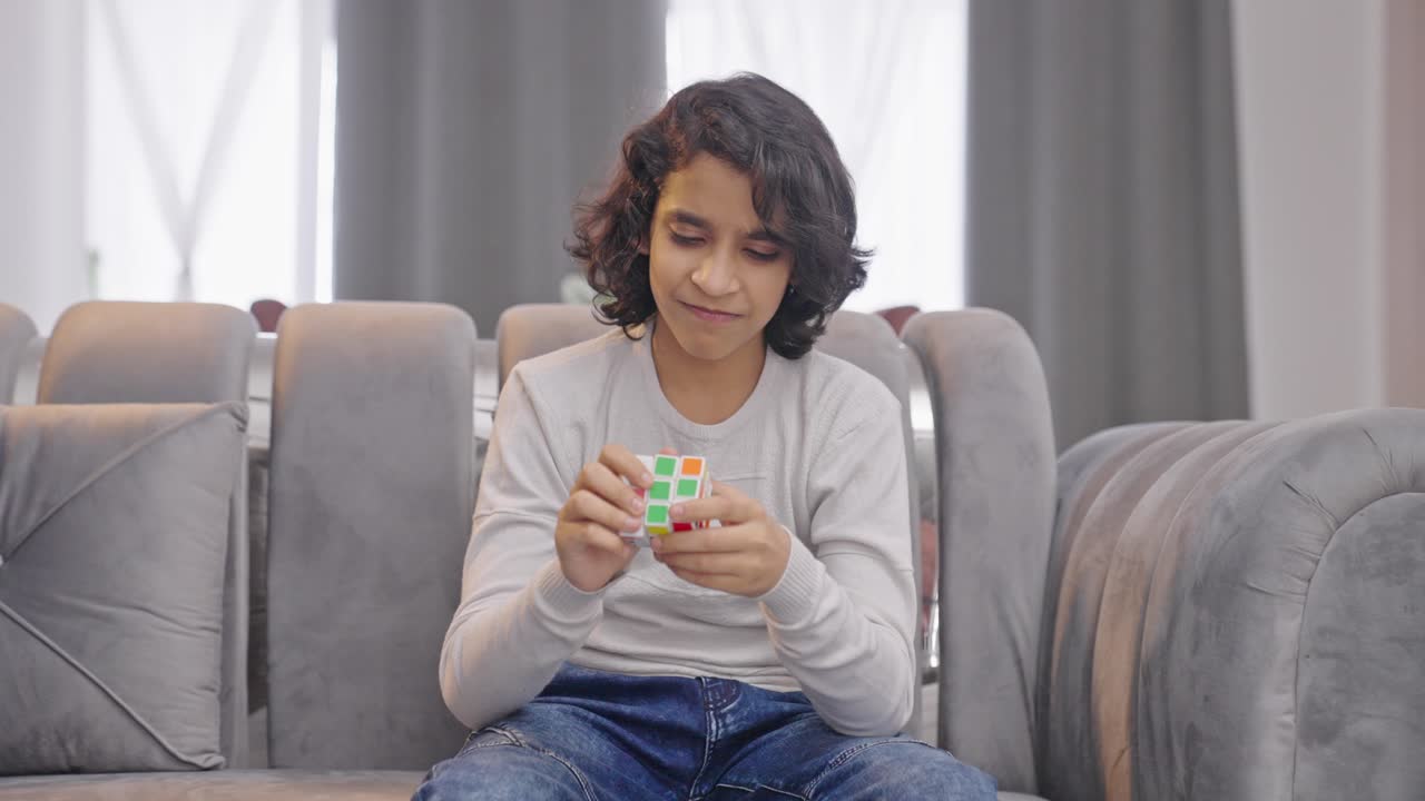 Angry Indian kid boy gets frustrated unable to solve Rubik's cube