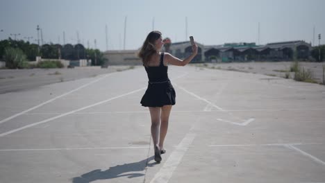 woman taking a selfie in an empty parking lot