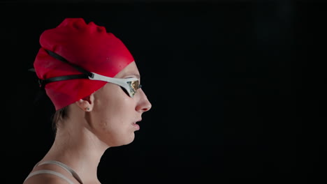 a female swimmer standing at the edge of a pool, ready to compete.