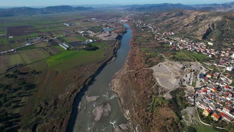 river of shkumbin in albania flowing through agricultural parcels and countryside