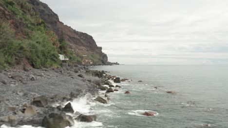 costa salvaje y escarpada de madeira con rocas y guijarros de basalto volcánico oscuro