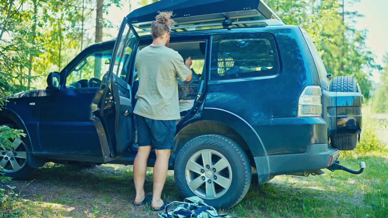 Un viaggiatore carica l'auto, preparandosi a guidare verso nord sulla E6 da Fosen, Trøndelag, Norvegia - Primo piano.