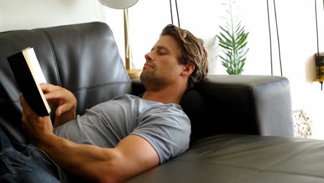 hombre leyendo un libro en la sala de estar 4k