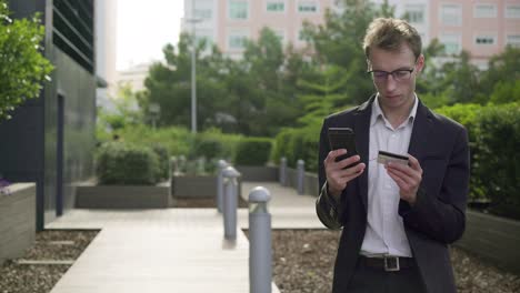 Hombre-Serio-Poniendo-Datos-De-Tarjetas-Bancarias-En-El-Teléfono,-Pagando-En-Línea