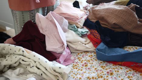 messy pile of clothes on a bed