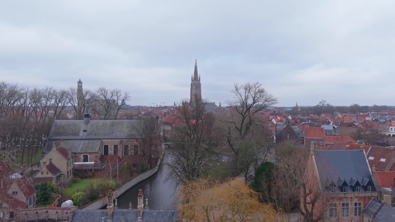 Superbes images du Lac d'Amour Minnewater à Bruges, avec le beffroi historique et l'architecture médiévale en arrière-plan. Une scène paisible dans la ville classée au patrimoine de l'UNESCO.