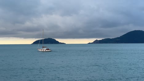sail booat and light house before the storm