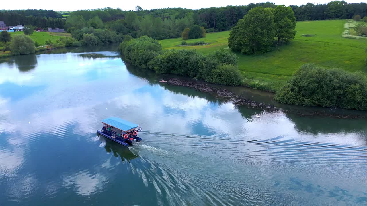 Vista aerea di una barca su un lago calmo circondato da una vegetazione lussureggiante