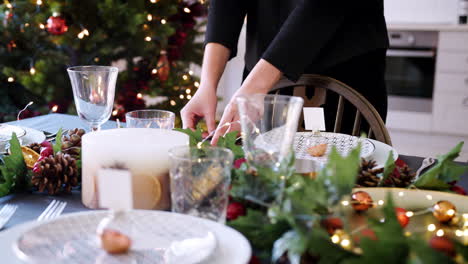 Mittelteil-Einer-Frau,-Die-Besteck-Auf-Einen-Für-Das-Weihnachtsessen-Dekorierten-Esstisch-Legt,-Selektiver-Fokus