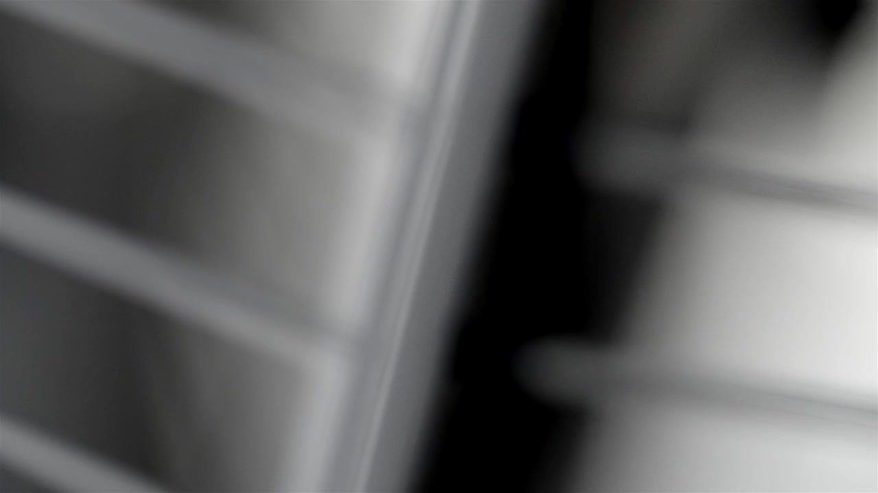 Blurred fan grille and blades fill the frame as the blades shift in close-up.