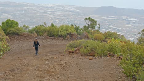Casual-woman-walking-down-trekking-pathway-in-mountains-of-Tenerife