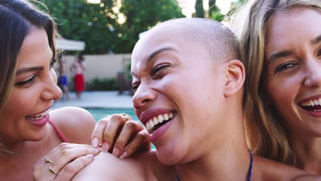 portrait of three female friends outdoors relaxing in swimming pool and enjoying summer pool party