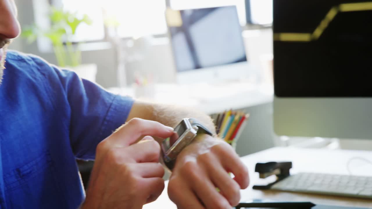ejecutivo de negocios masculino ajustando el tiempo en el reloj inteligente