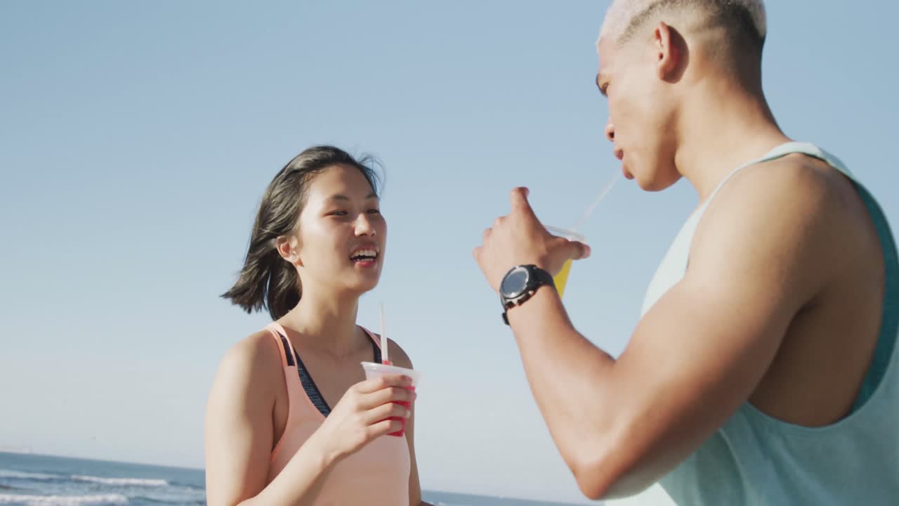 슬로우 모션으로 산책하고 주스를 마시는 행복한 두 인종 커플