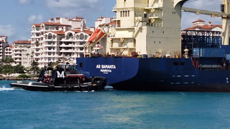 tug boat bringing big cargo ship coming into port