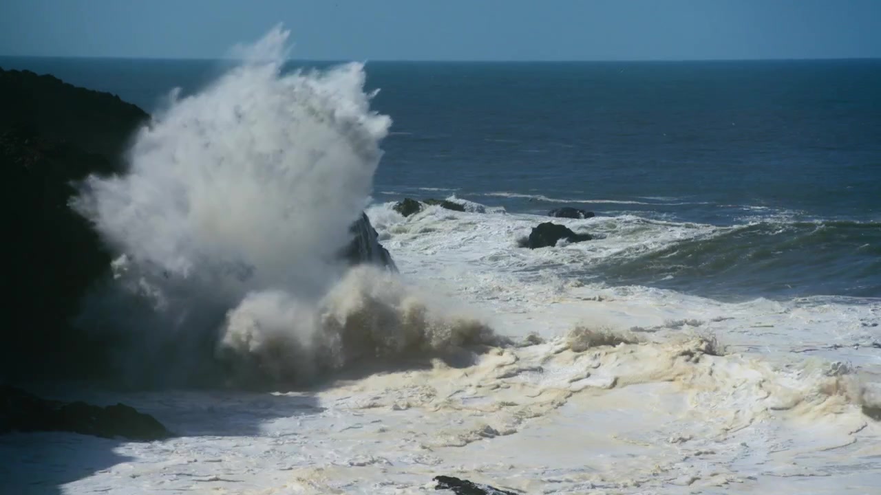 Store bølger der slår mod klipperne ved Nazaré